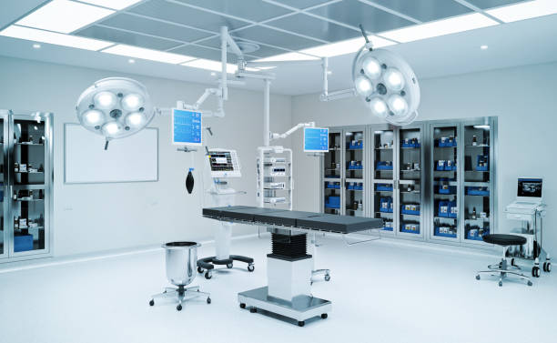 Modern ambulatory surgery center operating room with dual LED surgical lights, integrated AV monitor arms on adjustable booms, surgical table, anesthesia equipment, and clinical supply storage cabinets — representing the complete ASC IT stack ALIS Technology designs and integrates